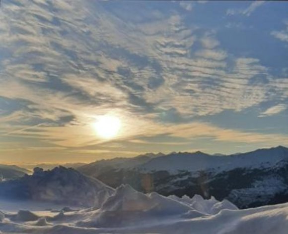 Sonne über schneebedeckten Bergen