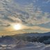 Sonne über schneebedeckten Bergen